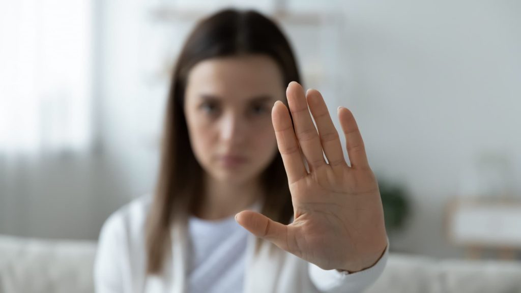 mujer con la mano abierta haciendo el gesto de parar
